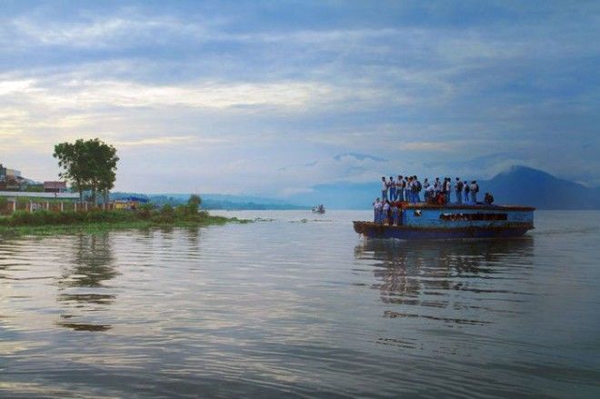 Дети на деревянной лодке по пути в школу в Индонезии